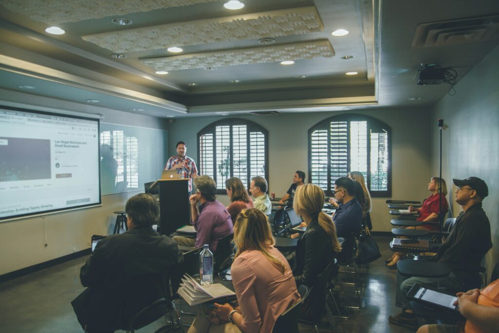 Groep volwassenen volgt een cursus met projectiescherm