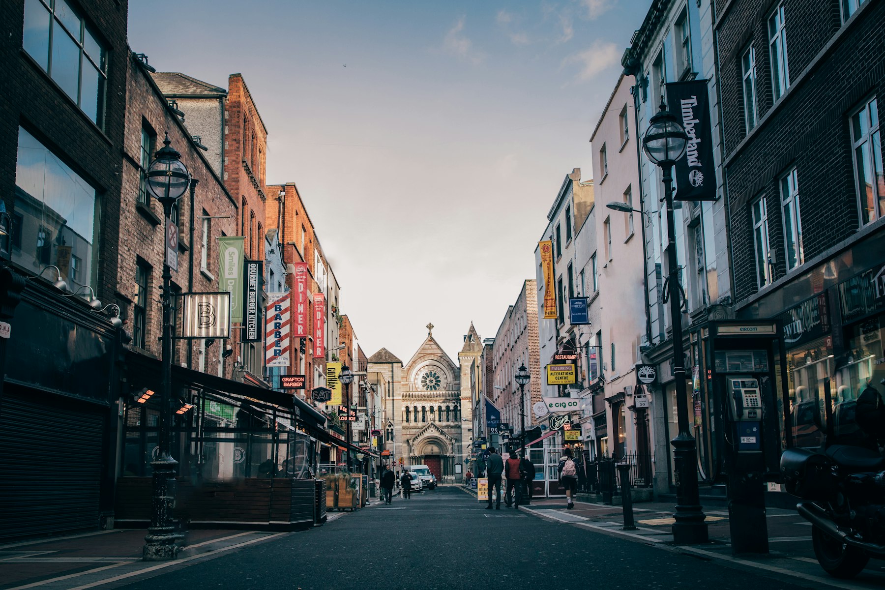 Straat in Dublin met voetgangers en een kerk